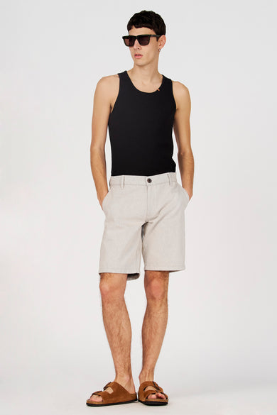 Zwarte tanktop van Le Fabuleux Marcel de Bruxelles, gedragen met korte broek en sandalen.