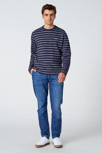7/8 jeans en denim bleu moyen de Le Fabuleux Marcel de Bruxelles, associés à une chemise rayée et des baskets blanches.