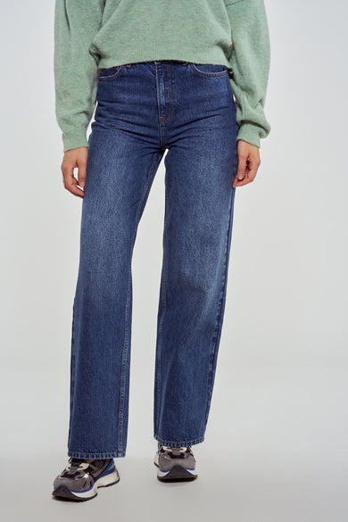 Donkerblauwe wide jeans van Le Fabuleux Marcel de Bruxelles, met een casual trui en sneakers.
