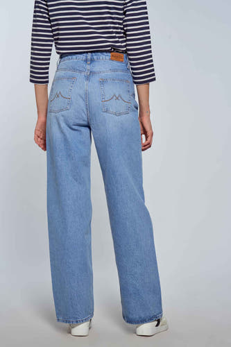 Lichtblauwe wijde jeans van Le Fabuleux Marcel de Bruxelles, met gestreepte top en witte schoenen.
