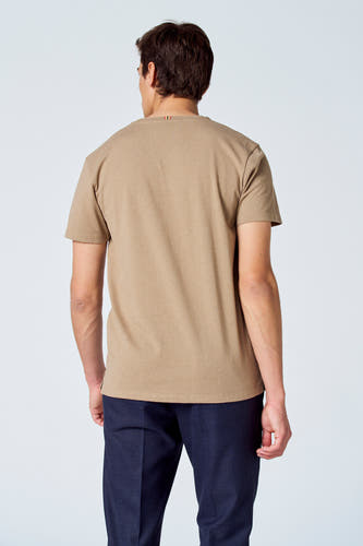 T-shirt beige de Le Fabuleux Marcel de Bruxelles, vu de dos, combiné avec un pantalon bleu foncé.