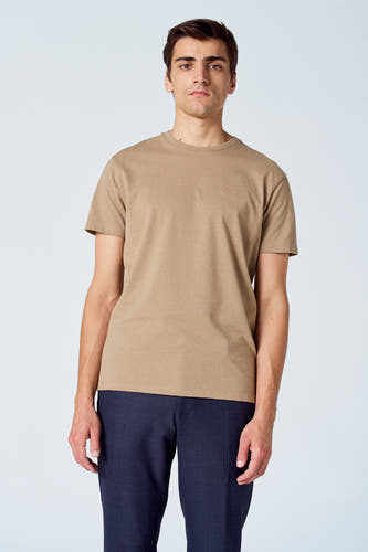T-shirt beige de Le Fabuleux Marcel de Bruxelles, combiné avec un pantalon bleu foncé.