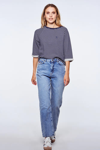 Blauwe rechte jeans van Le Fabuleux Marcel de Bruxelles, gecombineerd met gestreepte top en sneakers.
