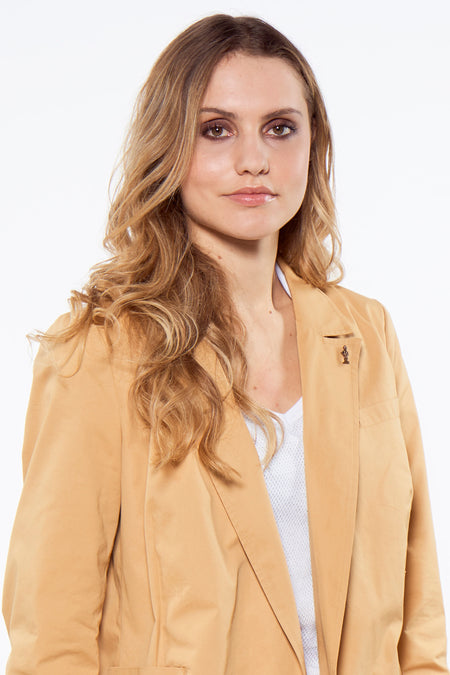 Bruine blazer van Le Fabuleux Marcel de Bruxelles, met een klein speldje en gedragen over een witte top.
