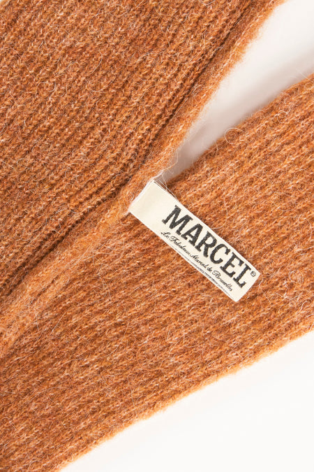 Bruine handschoenen van Le Fabuleux Marcel de Bruxelles, met een zachte, gebreide textuur en een label.

