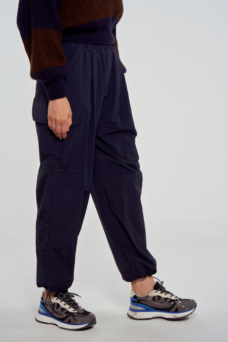 Pantalon de travail bleu Le Le Fabuleux Marcel de Bruxelles, avec poches et bords élastiques, en vue latérale.