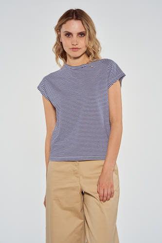 T-shirt rayé bleu de Le Fabuleux Marcel de Bruxelles, avec des manches courtes et un short beige.