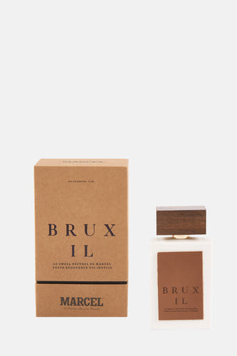 Parfum multicolore de Le Fabuleux Marcel de Bruxelles, avec des accents bruns et un bouchon en bois, à côté d'un emballage coordonné.