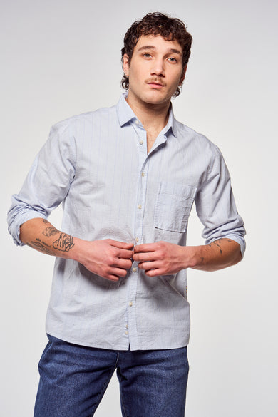 Blauw, gestreept overhemd met lange mouwen van Le Fabuleux Marcel de Bruxelles, gedragen met een donkere jeans.

