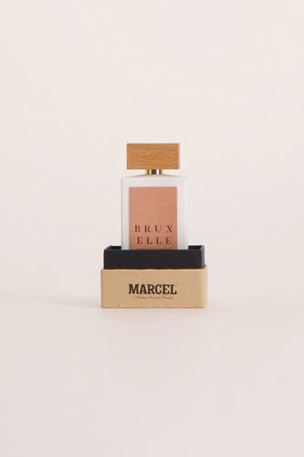 Multicolor parfum van Le Fabuleux Marcel de Bruxelles in een vierkant flesje met houten dop, geplaatst in een doosje.
