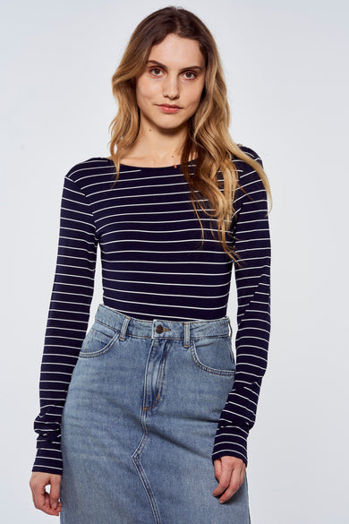 T-shirt bleu à manches longues avec des rayures blanches de Le Fabuleux Marcel de Bruxelles, porté avec une jupe en denim, vue de face