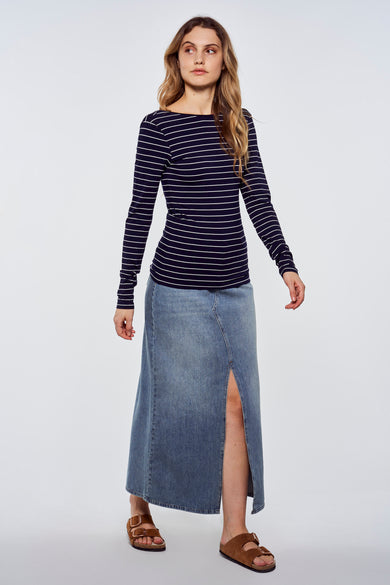 T-shirt bleu à manches longues avec rayures blanches de Le Fabuleux Marcel de Bruxelles, porté avec une jupe en jean et des sandales marron, vue de face