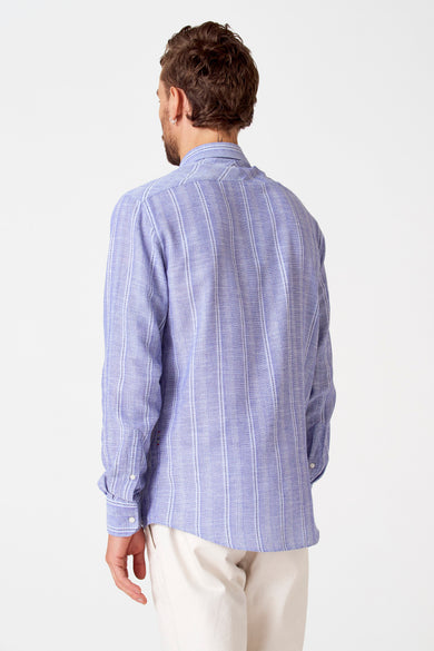 Blauw gestreept overhemd van Le Fabuleux Marcel de Bruxelles, gezien van achteren, met lange mouwen en witte broek.
