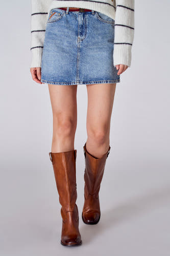 Korte lichtblauwe denim rok van Le Fabuleux Marcel de Bruxelles, gedragen met bruine leren laarzen en een gestreepte trui.
