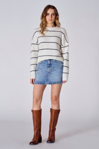 Korte lichtblauwe denim rok van Le Fabuleux Marcel de Bruxelles, gecombineerd met een gestreepte trui en bruine laarzen.
