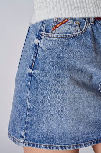 Korte lichtblauwe denim rok van Le Fabuleux Marcel de Bruxelles, met een decoratieve streep bij de zak.