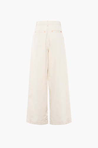 Pantalon blanc de Le Fabuleux Marcel de Bruxelles, avec des boutons orange et des larges pinces, vu de derrière.