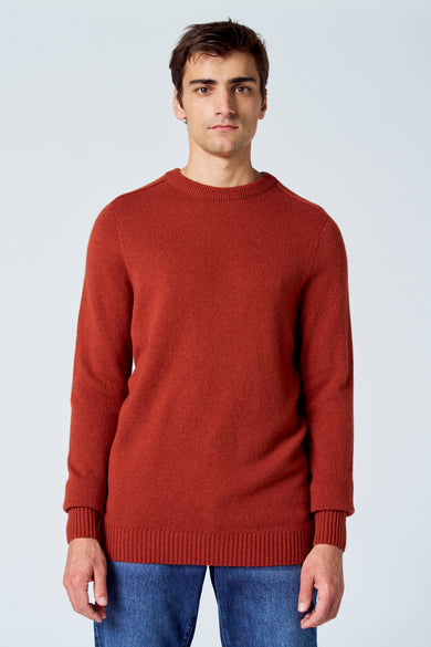 Bordeaux trui met ronde hals van Le Fabuleux Marcel de Bruxelles, gedragen met een blauwe jeans.
