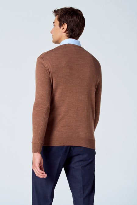 Pull marron avec col rond de Le Fabuleux Marcel de Bruxelles, porté sur une chemise bleue claire et un pantalon bleu foncé, dos.