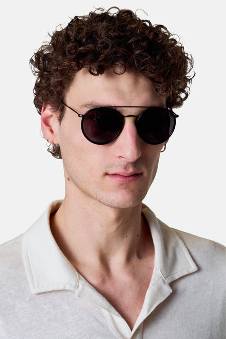 Multicolor zonnebril van Le Fabuleux Marcel de Bruxelles, met zwarte monturen en gedragen door een model.