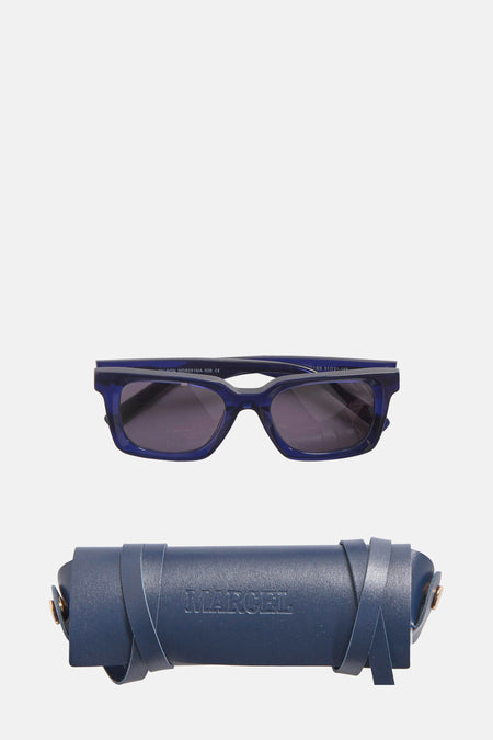 Blauwe zonnebril van Le Fabuleux Marcel de Bruxelles, met bijpassende donkerblauwe brillenkoker met leren bandjes.