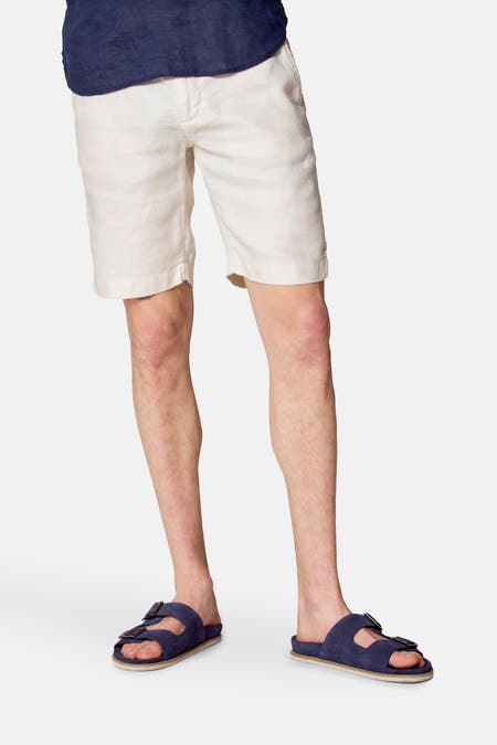 Beige court de Le Fabuleux Marcel de Bruxelles, porté avec des sandales bleues et un t-shirt bleu marine.