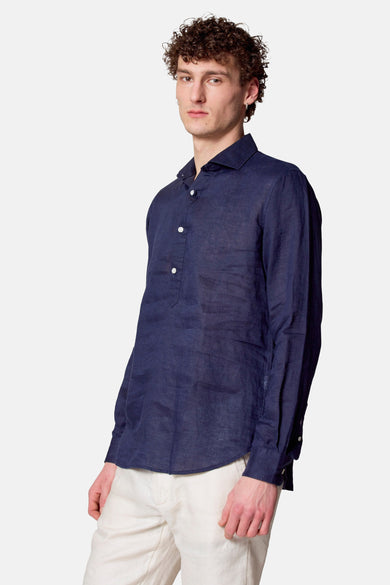 Blauw overhemd met lange mouwen van Le Fabuleux Marcel de Bruxelles, met witte knopen en een lichte pantalon.