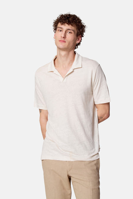 Beige polo met korte mouwen van Le Fabuleux Marcel de Bruxelles, gedragen met kaki broek.