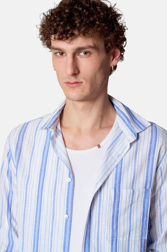 Blauw, gestreept overhemd met lange mouwen van Le Fabuleux Marcel de Bruxelles, gedragen over een wit hemd.
