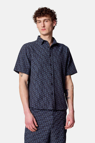 Blauw overhemd met korte mouwen van Le Fabuleux Marcel de Bruxelles, met een subtiel bloemmotief.
