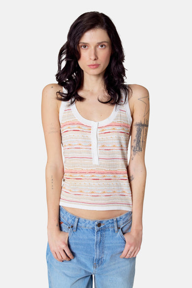 Multikleurige singlet van Le Fabuleux Marcel de Bruxelles, met een gestreept patroon en gedragen met een blauwe jeans.
