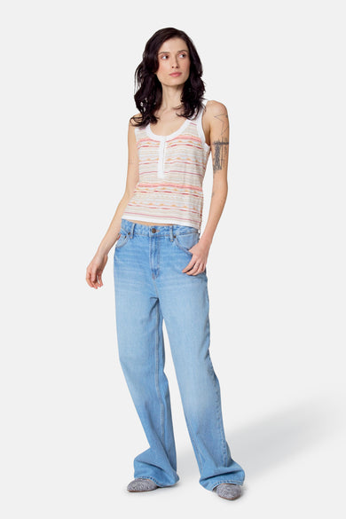 Multikleurige singlet van Le Fabuleux Marcel de Bruxelles, met horizontale strepen en gedragen met wijde jeans.
