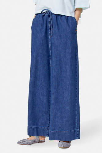 Wijde jeans van midblauw denim van Le Fabuleux Marcel de Bruxelles, met trekkoord in de taille en zebra-print instappers.
