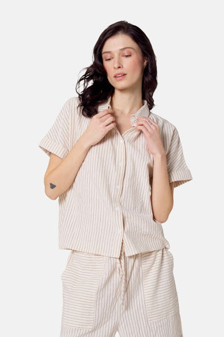 Chemise beige à manches courtes de Le Fabuleux Marcel de Bruxelles, avec des rayures verticales et une fermeture à boutons.