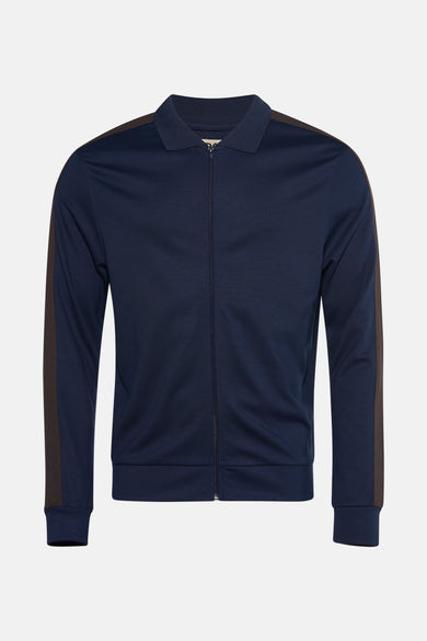 Jean bleu de Le Fabuleux Marcel de Bruxelles, avec des accents marrons sur les manches et le col.