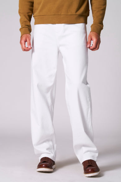 Jeans straight model van off white denim van Le Fabuleux Marcel de Bruxelles, met bruine schoenen en een bruin sweatshirt.