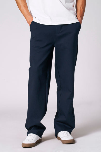 Blauwe joggingbroek van Le Fabuleux Marcel de Bruxelles, met een witte T-shirt en witte sneakers.
