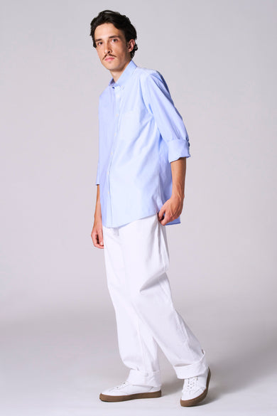 Chemise bleue à manches longues de Le Fabuleux Marcel de Bruxelles, avec poche poitrine rayée et col boutonné.