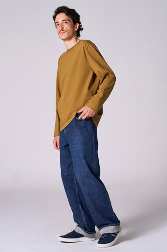 Beige T-shirt met lange mouwen van Le Fabuleux Marcel de Bruxelles, met donkerblauwe jeans en donkerblauwe sneakers.
