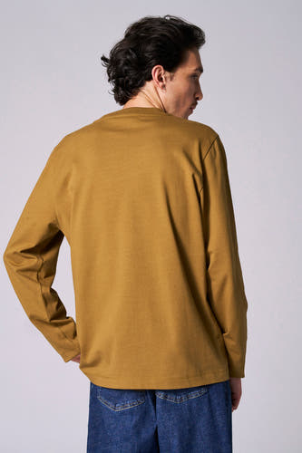 Beige T-shirt met lange mouwen van Le Fabuleux Marcel de Bruxelles, gezien van achteren, gecombineerd met een blauwe jeans.
