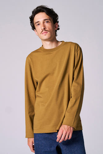 Beige T-shirt met lange mouwen van Le Fabuleux Marcel de Bruxelles, gedragen met een donkerblauwe spijkerbroek.
