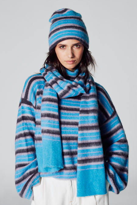 Wintersjaal in multicolor van Le Fabuleux Marcel de Bruxelles, met horizontale strepen en bijpassende muts en trui.