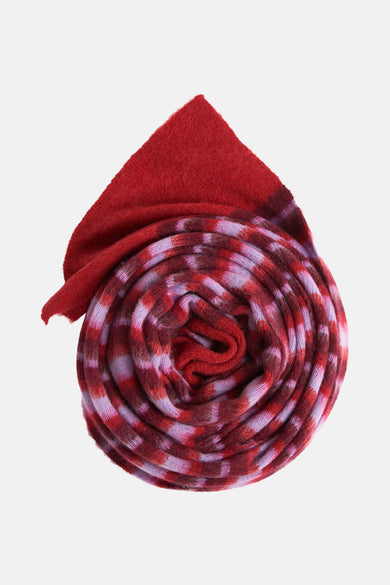 Multikleurige wintersjaal van Le Fabuleux Marcel de Bruxelles, opgerold met rood en paars gestreept patroon.