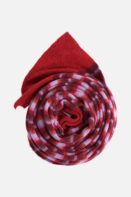 Multikleurige wintersjaal van Le Fabuleux Marcel de Bruxelles, opgerold met rood en paars gestreept patroon.