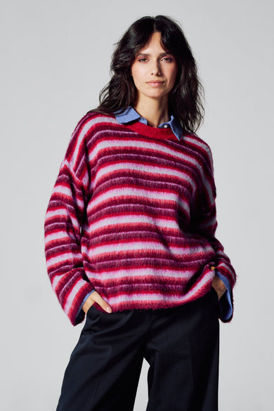 Sweat-shirt multicolore à col rond de Le Fabuleux Marcel de Bruxelles, avec des rayures horizontales et porté sur une chemise bleue.