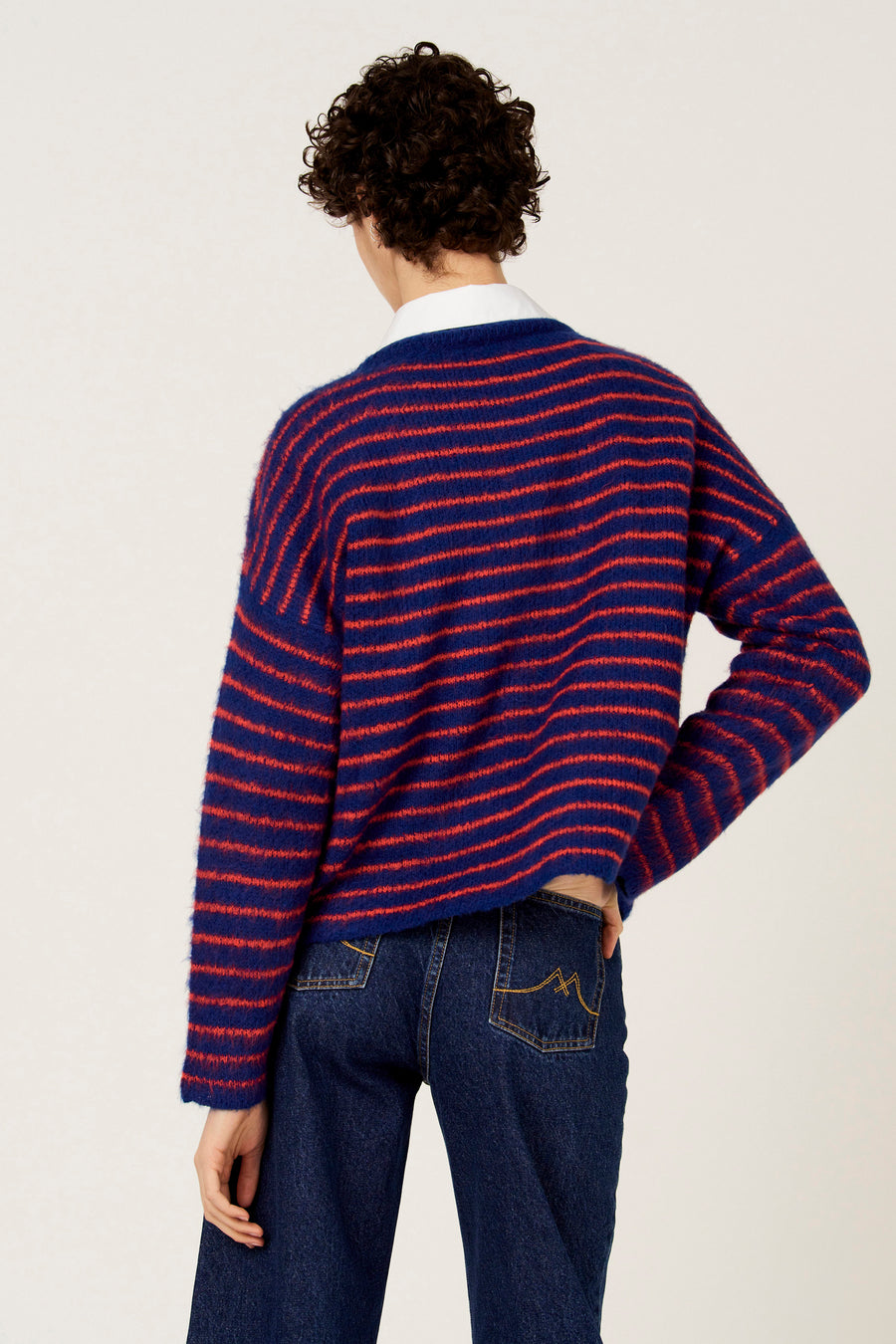 Multikleurige trui met ronde hals van Le Fabuleux Marcel de Bruxelles, met horizontale strepen en gedragen met een donkere jeans.
