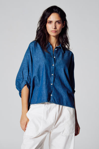 Donkerblauw denim hemd met korte mouwen van Le Fabuleux Marcel de Bruxelles, gecombineerd met een witte broek.