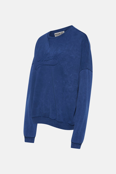 Gilet bleu de Le Fabuleux Marcel de Bruxelles avec texte brodé sur l'avant.