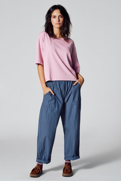 Blauwe 7/8 broek van Le Fabuleux Marcel de Bruxelles, met steekzakken en opgerolde pijpen.
