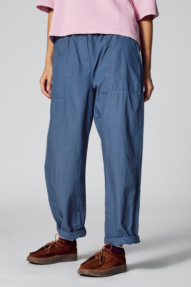 Blauwe 7/8 broek van Le Fabuleux Marcel de Bruxelles, met opgerolde pijpen en bruine schoenen.
